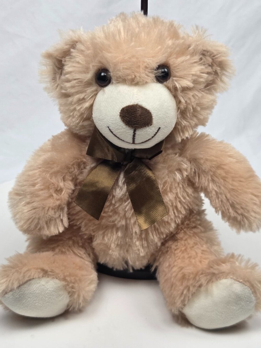 light brown plush teddy bear featuring a brown satin bow 9"